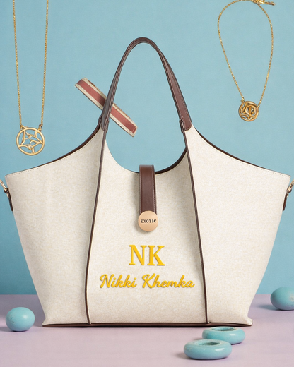 White handbag with brown handles and trim, featuring 'NK' and 'Nikki Khanka' branding, on a light blue background.
